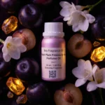 Black Plum Freesia Amber perfume oil bottle with dark plums, freesia flowers and glowing amber crystals under night lighting.