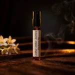 Leather Amber Jasmine perfume oil bottle with suede leather texture, warm amber glow and elegant jasmine atmosphere.